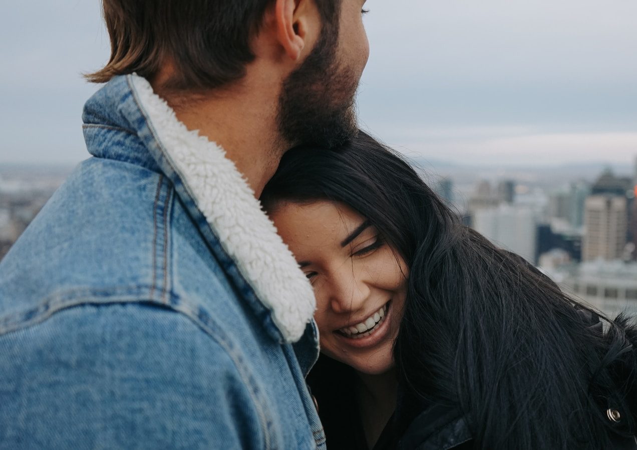 man and woman cuddling on rooftop